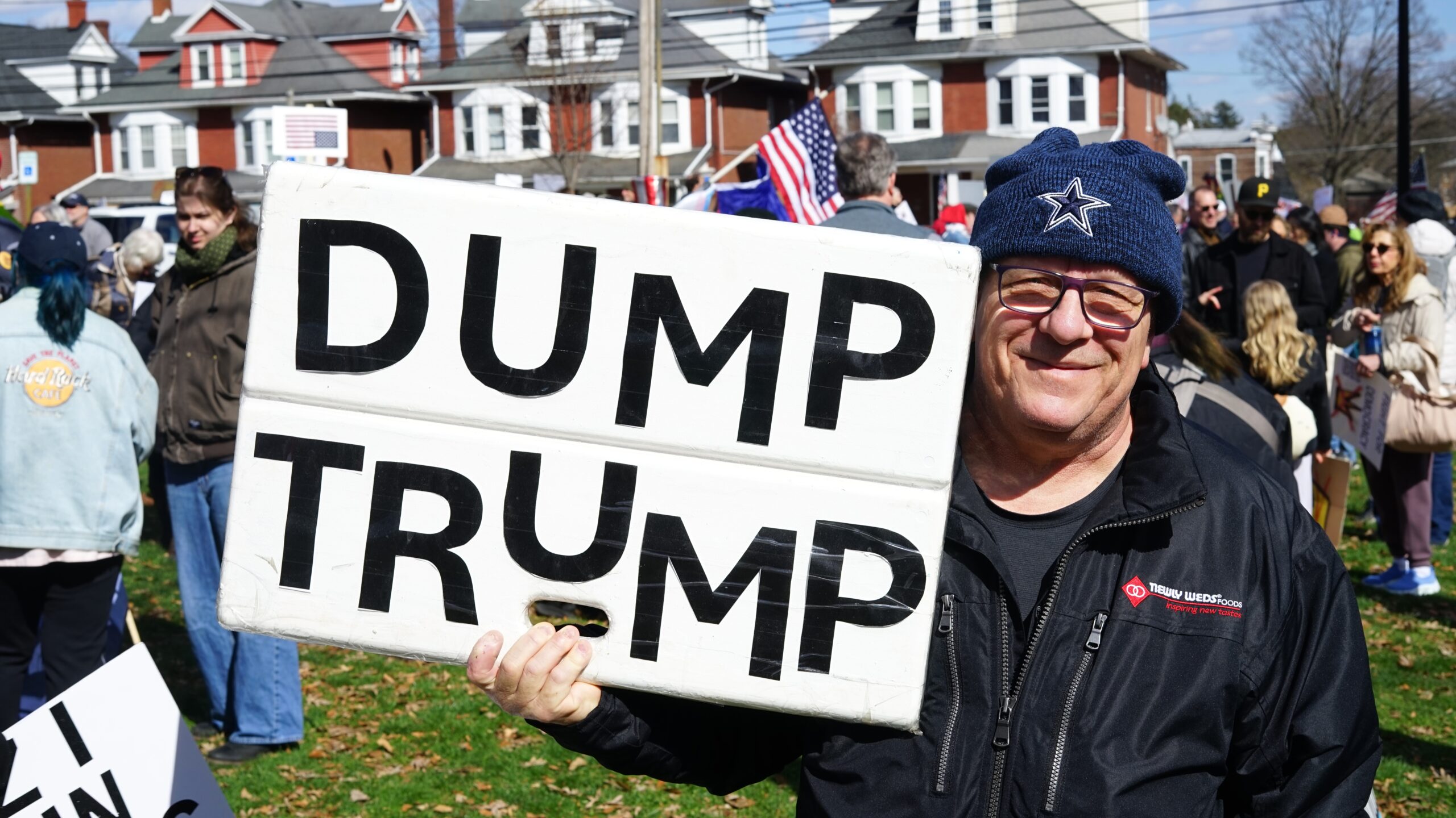 man holding dump trump sign protest bethlehem rose garden mar 28 2026