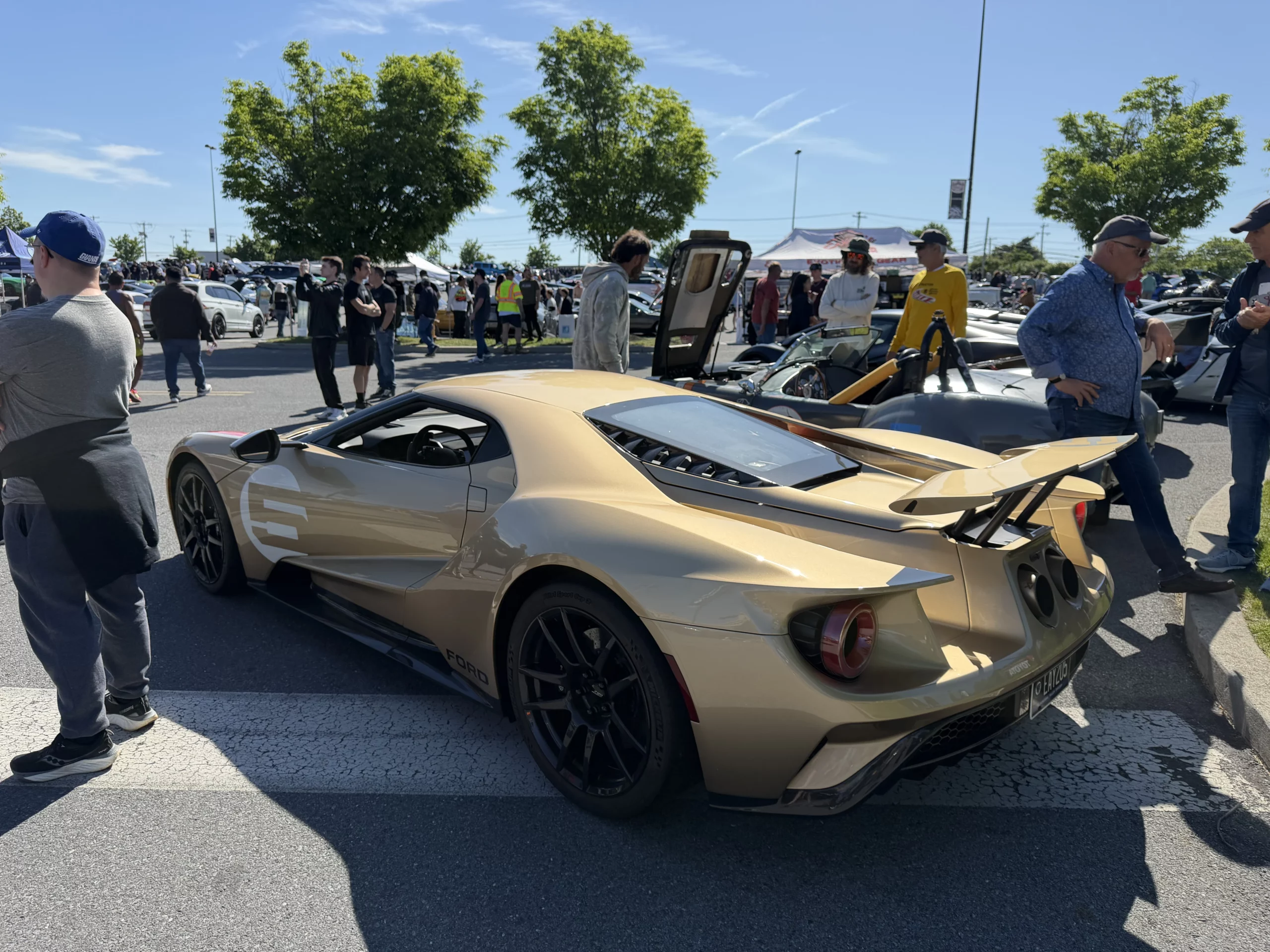 A gold second-generation Ford GT supercar surrounded by spectators
