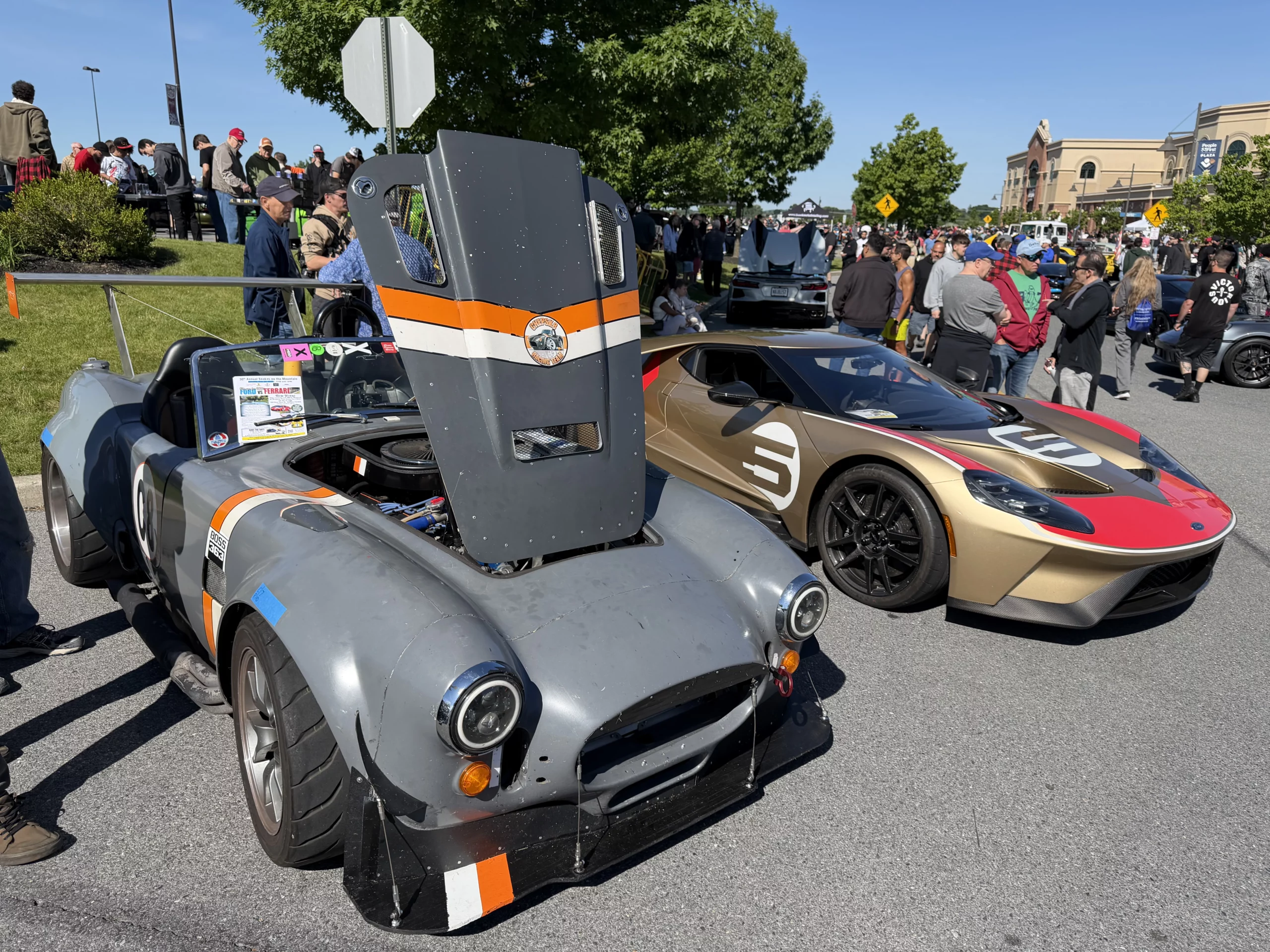 A gold Ford GT next to a grey Shelby Cobra-style roadster