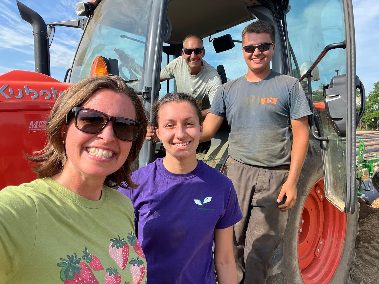 Deb, Calli and Nico Colitas, from left, smile for a selfie in front of a red Kubota tractor in a field at Valley Fruits & Veggies in Bath, Pa., with Chris Colitas in the tractor cab behind them.