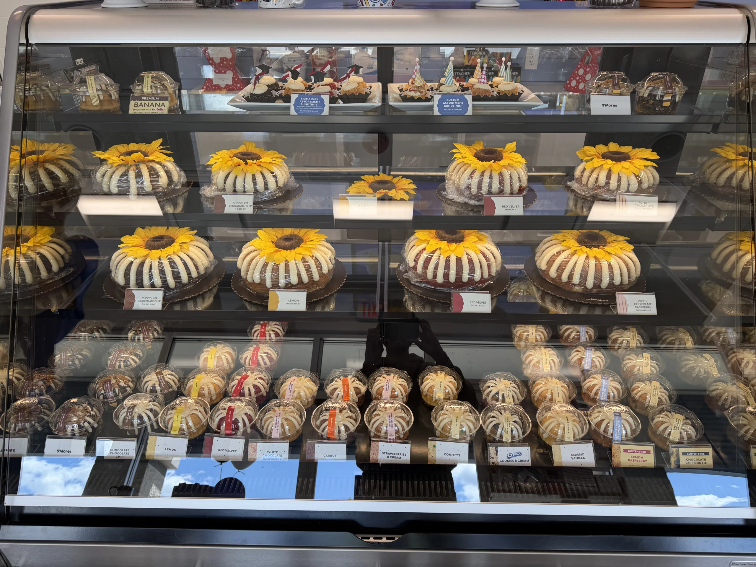 A bakery case filled with decorated Bundt cakes and individual Bundtlets at Nothing Bundt Cakes in Easton.