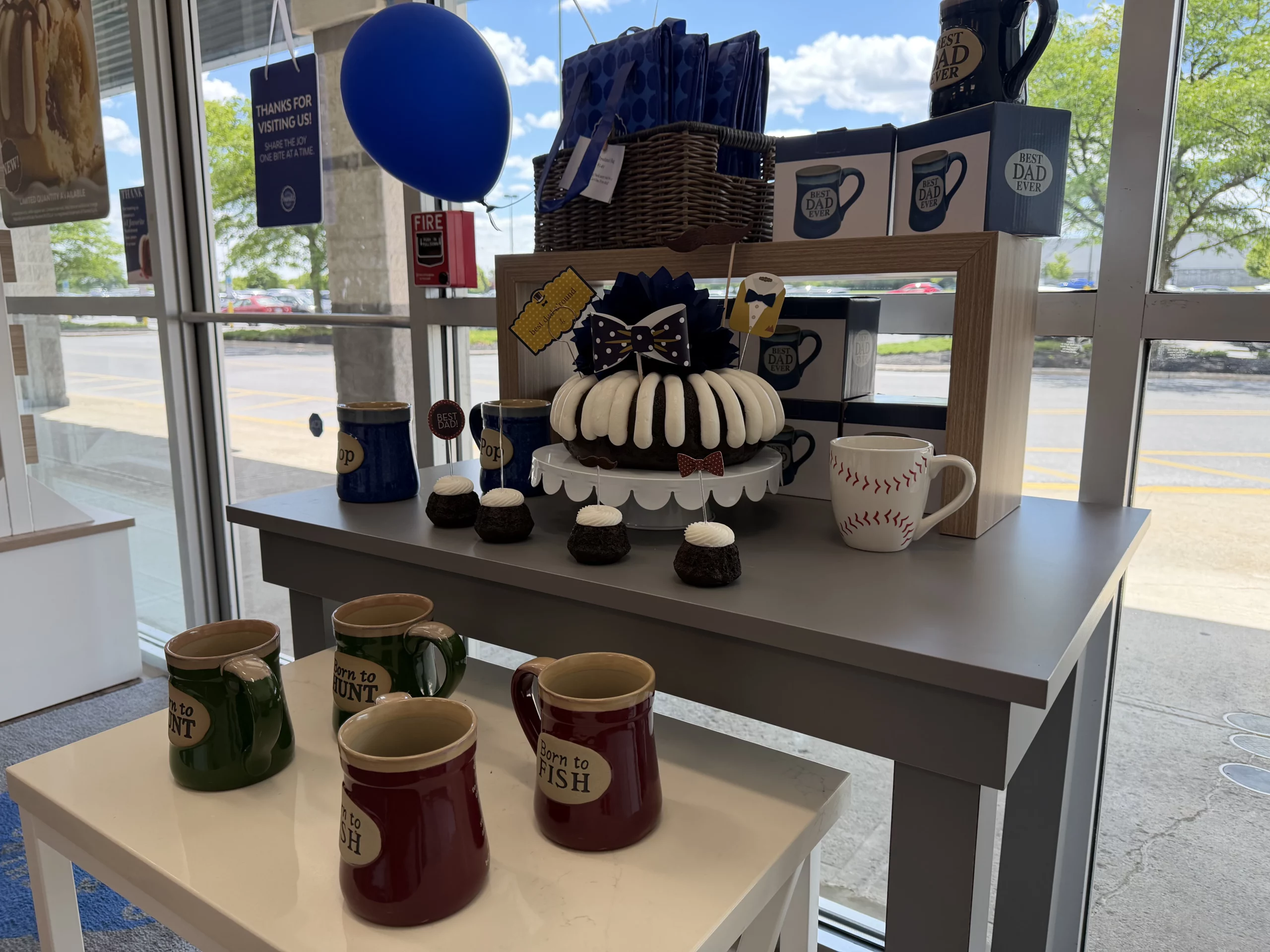 A retail display with mugs, gift items, balloons and decorated Bundt cakes inside Nothing Bundt Cakes in Easton.